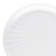 A 12" clear Pavilion round disposable plastic tray from the Kaya Collection with a textured, sunburst-like pattern radiating from the center is shown against a plain white background. This premium quality product exudes elegance with only a portion visible in the image.