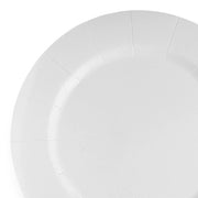 A close-up image showcases an elegant disposable plate from the White Round Disposable Paper Charger Plates (13") collection. The plate boasts a slightly textured white surface and prominently visible folded edges that form a decorative pattern around its rim. Only a portion of the plate is visible in the image.