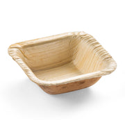 A small, square-shaped, eco-friendly disposable plate made from natural fallen leaves, featuring a light brown color and a slightly textured surface. Known as the Square Palm Leaf Eco Friendly Mini Disposable Plate (3"), it has gently sloping sides and a shallow depth, making it ideal for serving food.