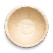 An overhead view of an empty Round Palm Leaf Eco Friendly Disposable Soup Bowl (5.5 oz.) reveals its smooth, slightly textured surface and round shape. The natural finish and visible wood grain pattern highlight the bowl's eco-friendly design, emphasizing its biodegradable and compostable qualities against a white background.