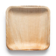 The Kaya Collection Square Palm Leaf Eco-Friendly Disposable Appetizer/Salad Plates (6") are crafted from natural palm leaf material. These biodegradable and compostable plates feature a light tan color with delicate, organic patterns of the leaf's texture visible throughout. The corners are gently rounded, and the surface boasts a smooth, rustic appearance—perfect for disposable party plates.