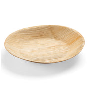 The Kaya Collection Round Palm Leaf Eco Friendly Disposable Salad Plate (7") is a shallow, round plate made of light-colored biodegradable palm leaf material. This piece of sustainable dinnerware features a textured natural wood grain pattern and is shown empty against a plain white background.