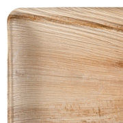 Close-up photo of a corner of a Square Palm Leaf Eco Friendly Disposable Buffet Plate from the Kaya Collection. The smooth edges and visible leaf grain texture are clearly shown. The finish displays a natural, light brown color with subtle horizontal and vertical lines, enhancing the organic look of this eco-friendly plate.