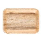 The Rectangular Natural Palm Leaf Eco-Friendly Disposable Plates (9" x 6") are compostable and biodegradable serving platters made of palm leaf. They have a natural wood grain texture with varying shades of light brown, slightly raised edges, and a smooth curved finish at the corners.