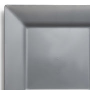 A close-up of the corner of a 9.5-inch square, gray, glossy plastic plate from the Silver Square Plastic Dinner Plates collection. The plate's smooth surface reflects light slightly against a white background, capturing only a portion that emphasizes its clean and minimalist design—ideal for elegant disposable dinner settings.