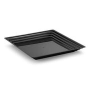 The 12" x 12" Black Square with Groove Rim Plastic Serving Tray features an elegant, minimalist design with slightly raised edges. Its modern aesthetic is highlighted by progressively smaller square ribbed lines inside the border, creating a geometric pattern on a plain white background.