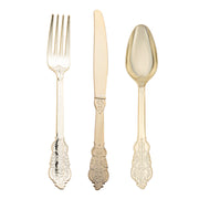 A luxurious gold-colored fork, knife, and spoon with detailed engraved patterns on their handles are arranged neatly side by side against a white background. This Kaya Collection Shiny Metallic Gold Baroque Plastic Cutlery Set of 24 spoons, 24 forks, and 24 knives exudes a sophisticated vintage charm that replicates the elegance of metallic gold cutlery in its refined design.