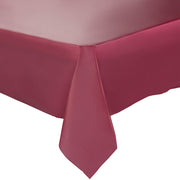 A corner of a bed is shown with a fitted bed sheet in a rich burgundy color. The sheet is neatly tucked, slightly draping over the corner to highlight the fabric's quality and snug fit. The background is plain white, evoking the elegance of Burgundy Rectangular Disposable Plastic Tablecloths (54" x 108"), similar to those used for party table decor.