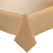 A close-up image of a Gold Rectangular Disposable Plastic Tablecloth (54" x 108") neatly draped over the edge of a rectangular table. The corner of the tablecloth hangs down, showcasing the fabric's smooth and slightly glossy texture. The background is plain white.