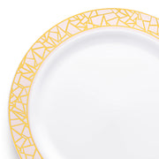 The White with Pink and Gold Mosaic Rim Round Plastic Dinner Plate (10.25") from our elegant tableware collection features a decorative border along the rim, consisting of a golden, geometric, mosaic-like pattern with subtle hints of pink. This sophisticated and modern plate is empty and placed against a plain white background.