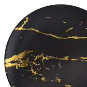 Close-up of a Black with Gold Marble Stroke Round Disposable Plastic Dinner Plate (10.25") featuring an abstract design with irregular gold streaks and patterns radiating across its surface. The gold patterns, reminiscent of elegant disposable dinner plates, appear randomly scattered, adding a touch of elegance to the modern design.