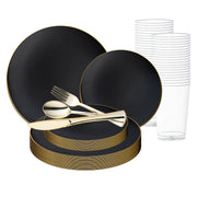 The Smarty had a party Black with Gold Rim Organic Round Disposable Plastic Wedding Value Set is on display. It features disposable plates adorned with gold rims, elegant gold flatware (fork, knife, and spoon), and clear plastic cups arranged neatly in the background—perfect for a stylish wedding set.