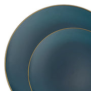 Two overlapping circular plates showcase a smooth, matte, dark teal finish complemented by thin gold rims. On the left side rests the larger plate, with the smaller plate partially placed on top of it to the right. This sophisticated set from Kaya Collection's "Navy with Gold Rim Organic Round Disposable Plastic Dinnerware Value Set" adds an elegant touch to any occasion against a plain white background.