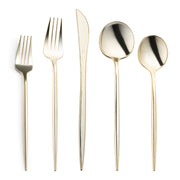 A set of five elegant utensils from the Shiny Gold Moderno Disposable Plastic Cutlery Set is arranged in a row against a white background. From left to right: a dessert fork, a dinner fork, a knife with a serrated edge, a soup spoon, and a teaspoon. Each gold disposable piece features slender and stylish designs perfect for any refined gathering.