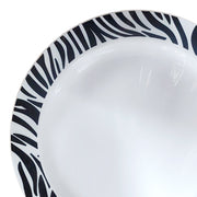 The White with Black Zebra Design Round Disposable Plastic Appetizer/Salad Plate (7.5") from the Kaya Collection features a striking zebra-stripe pattern along the rim. Inspired by safari themes, this glossy-finished plate provides a bold contrast against its smooth white surface, making it a stylish addition to any table setting.