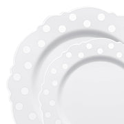 Close-up of two overlapping White with Silver Dots Round Blossom Disposable Plastic Dinnerware plates, each featuring a scalloped edge and a pattern of raised silver polka dots along the border. The plates have a clean and minimalistic design.