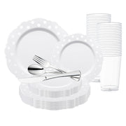 A set of White with Silver Dots Round Blossom Disposable Plastic Wedding Value dinnerware, including plates decorated with silver polka dots, plastic cutlery (spoon, fork, and knife), and clear plastic cups. The BPA-free dinnerware features a stylish decorative border with silver dots. The image displays multiple plates and cups stacked neatly alongside the cutlery arranged on a plate.