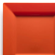 Close-up of the top right corner of an elegant Burnt Orange Square Plastic Dinner Plate (9.5") from Kaya Collection, featuring a shiny surface against a white background. The dinner plate showcases a subtle gradient, with the burnt orange color appearing slightly darker towards the edge and brighter towards the center.