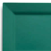 An image depicting a 9.5" square Hunter Green Plastic Dinner Plate from the Kaya Collection, featuring a wide, slightly raised border. The plate's clean lines and solid hunter green color offer it a modern, minimalist aesthetic. Its smooth and glossy surface reflects light, making it an elegant choice among disposable dinner plates.