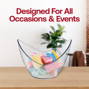 A clear, curved bowl brimming with colorful, assorted candies sits on a wooden surface. Next to it, a few 2 oz. Clear Small Disposable Plastic Concave Cups are neatly arranged. In the background, a green potted plant is slightly blurred, and bold red text above reads, "Designed For All Occasions & Events.