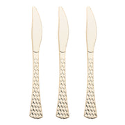 An image of three Shiny Gold Glamour Cutlery Disposable Plastic Knives with a textured, hammered design on the handles, arranged vertically in a row against a white background. The elegant plastic knives feature smooth blades with a slight serration on one side, perfect for party cutlery.